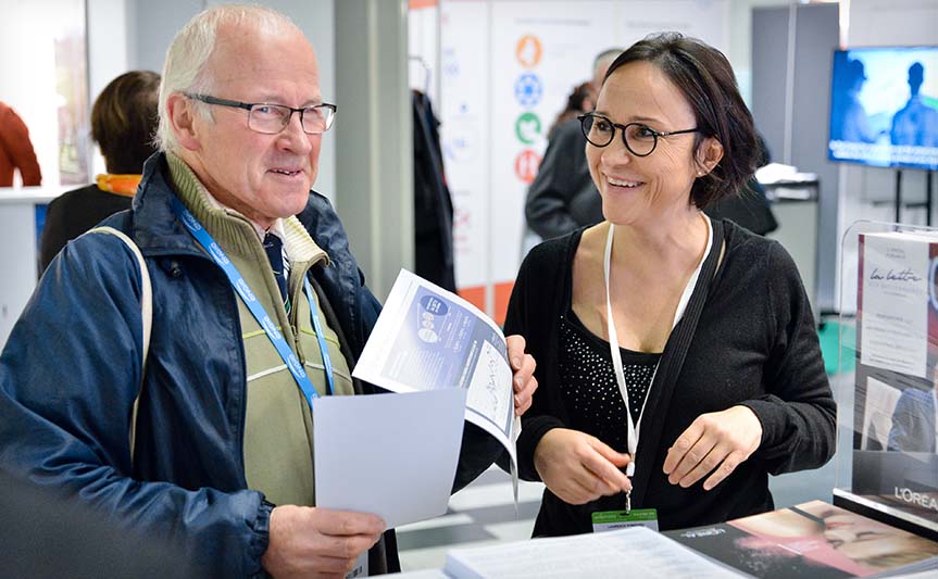 A member of the shareholder relations team talking to an attendee at the Actionaria Shareholder Fair