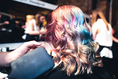 Young woman having her hair done backstage at the Hair Fashion Night